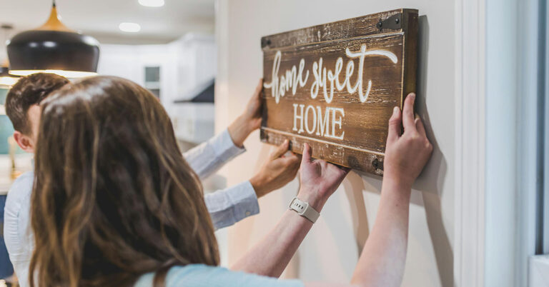 People hanging Home Sweet Home in their house